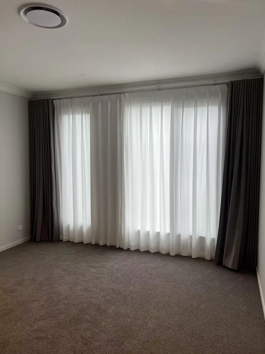 Layered sheer and blockout custom curtains in a Brisbane bedroom