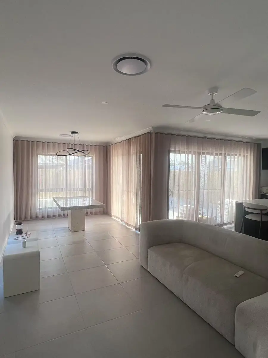 Blush S-fold sheer curtains in an open-plan Queensland living area