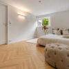 ArtiFloor Premium Herringbone Sandlight vinyl flooring installed in a bedroom