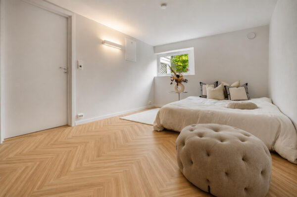 ArtiFloor Premium Herringbone Sandlight vinyl flooring installed in a bedroom