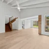 Living room with raked ceiling and timber staircase on BestBuys Neutral Oak hybrid flooring